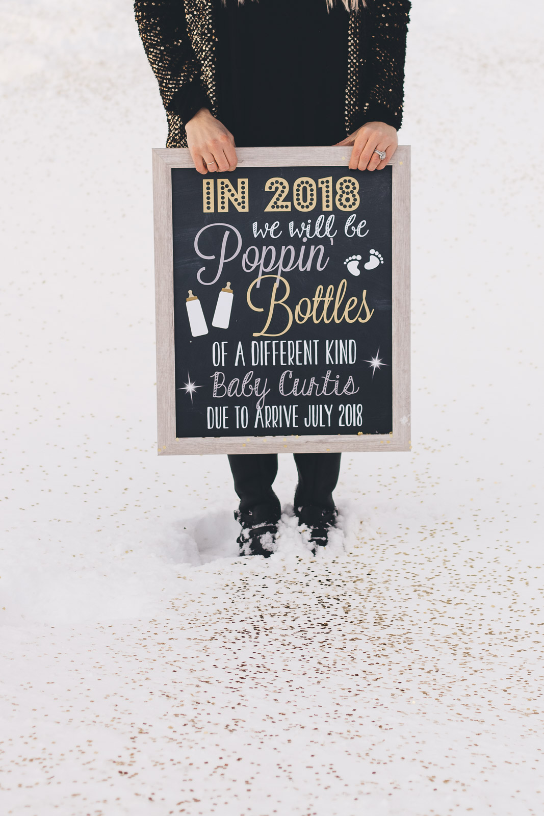 New Year's Eve pregnancy announcement with chalkboard sign. 