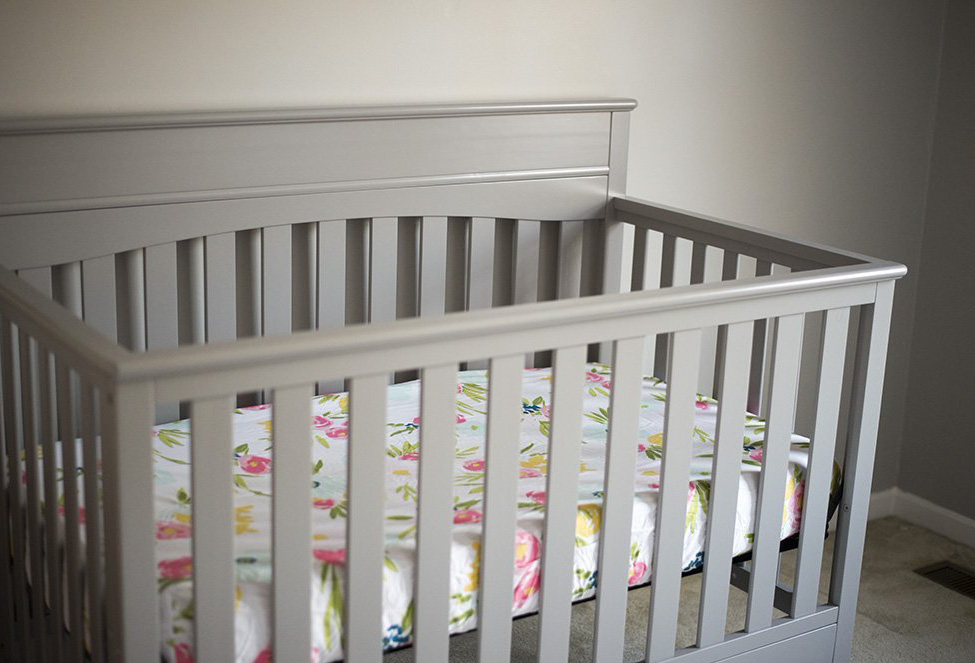 Gray crib for a baby girl nursery. 